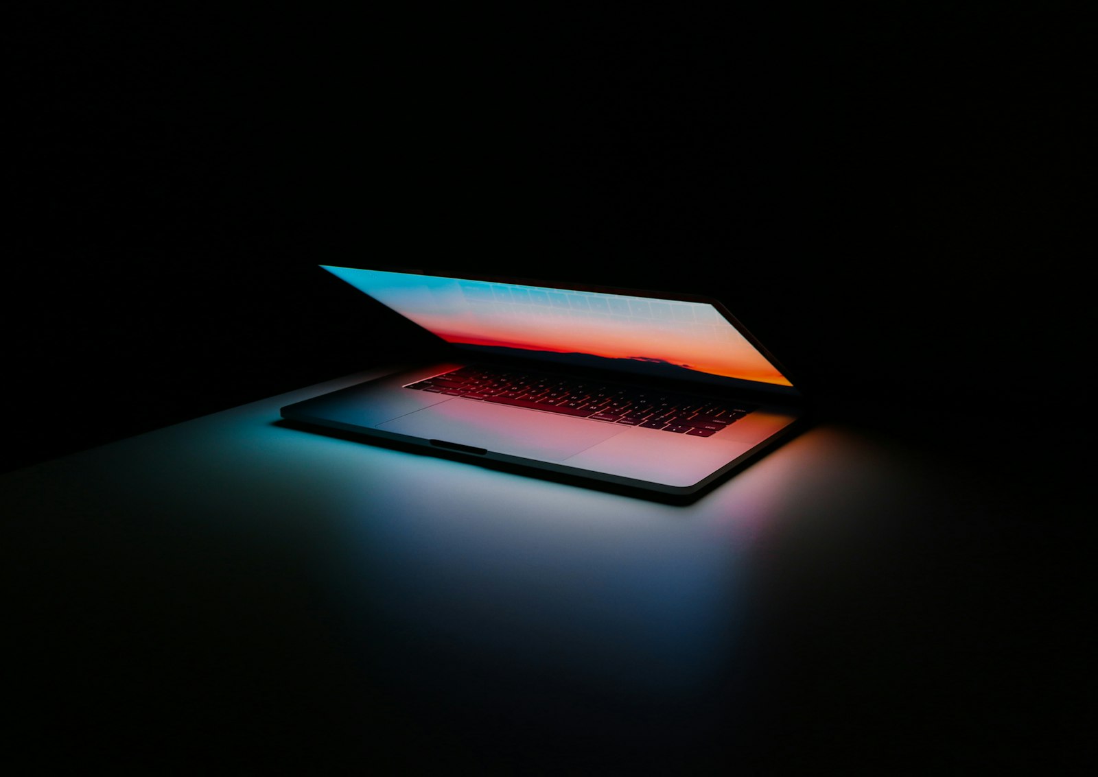A laptop in a dark room, screen lit — a human day made easier
