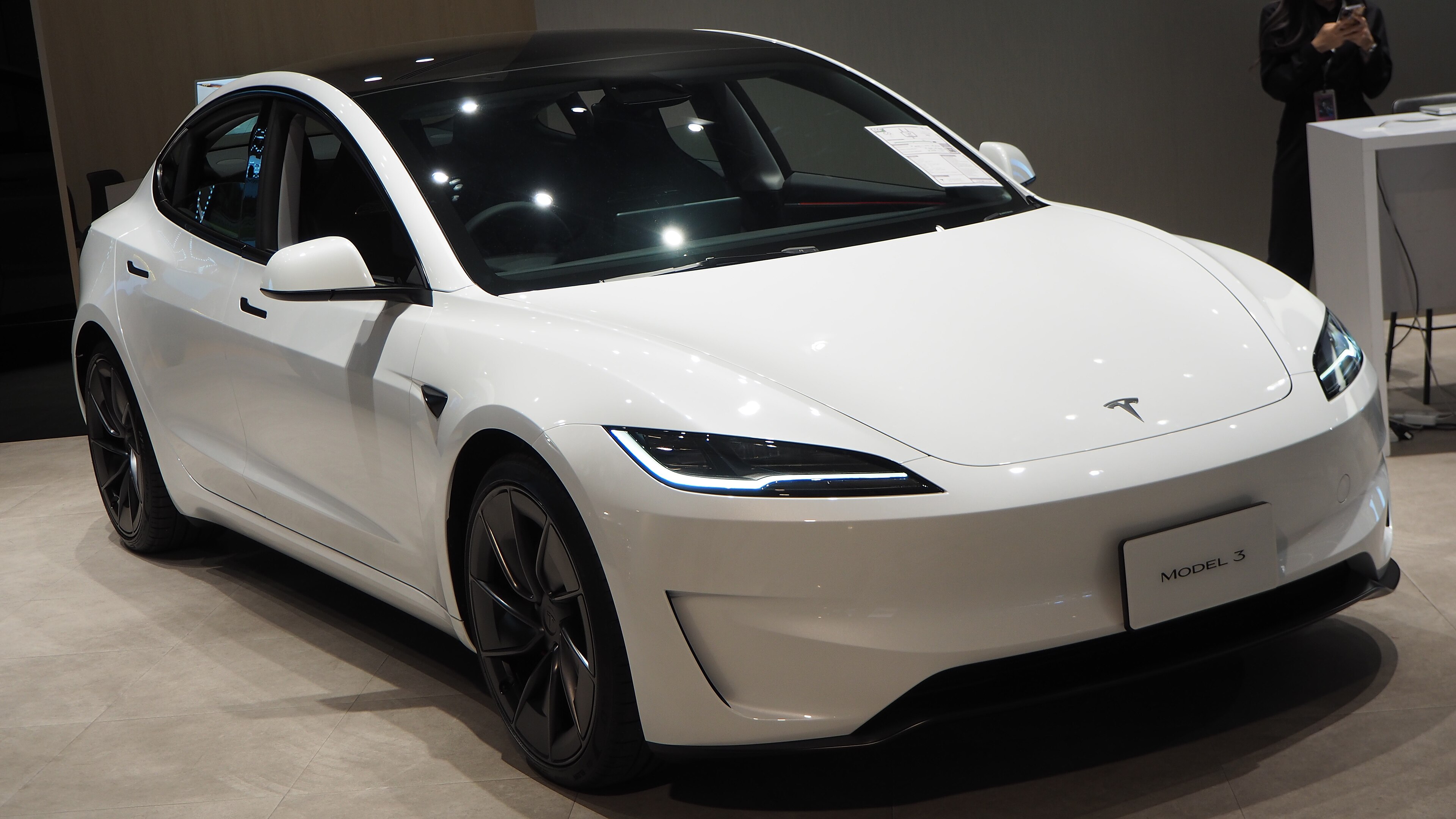 White 2024 Tesla Model 3 Highland Performance in a showroom